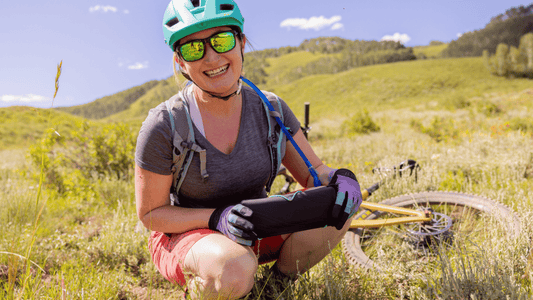 A woman holding the PACT Outdoor Bathroom Kit which makes it easy for women to pee and poop in the backcountry.